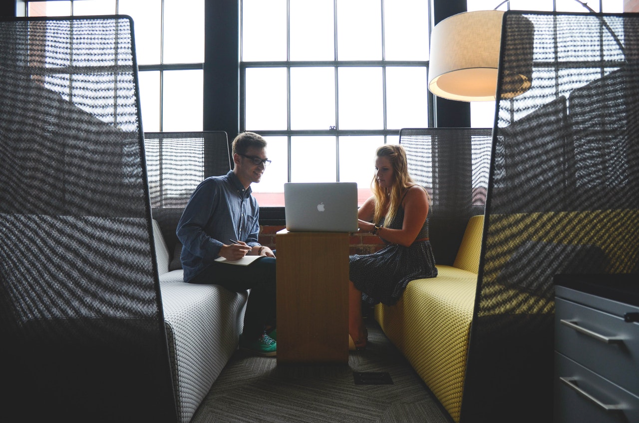 a man and woman looking at a laptop 