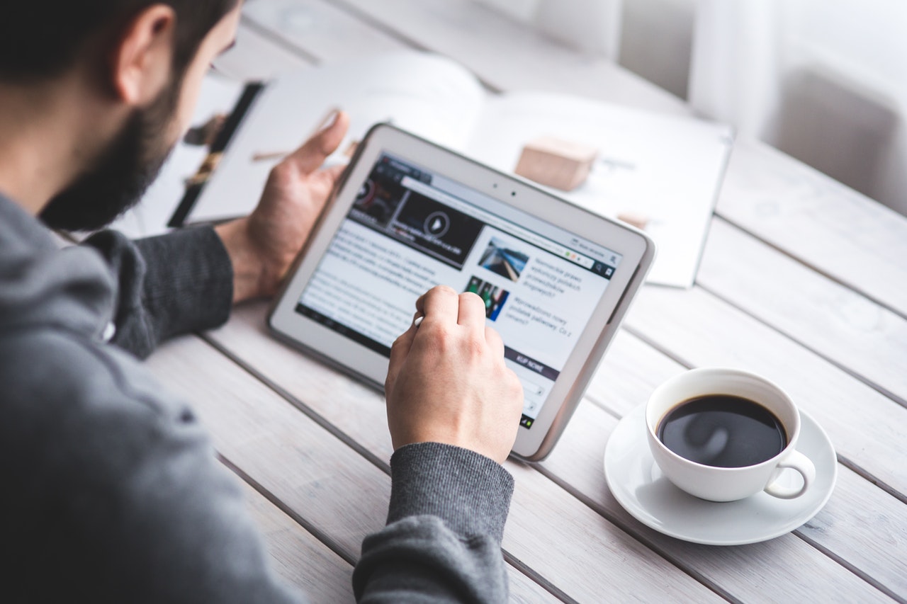 Man holding a stylus and using a tablet Man holding a stylus and using a tablet