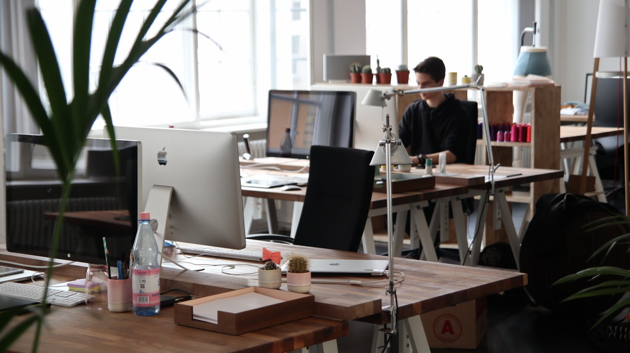 An office setting with a number of computers on wooden desks