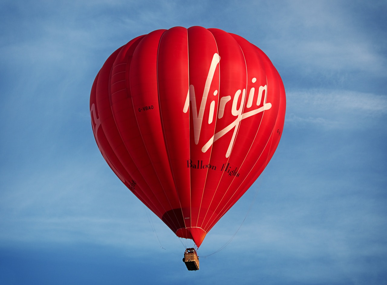 A red hot air balloon with the word Virgin written on it