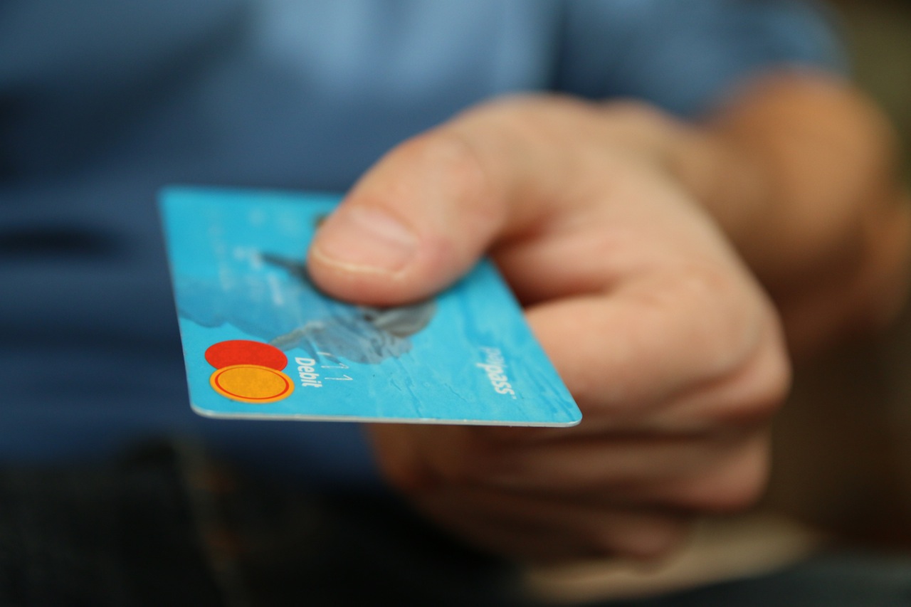 A man holding a blue credit card 