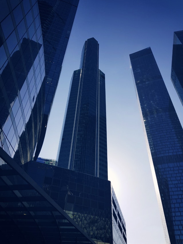 Blue glass panelled buildings against a clear evening sky