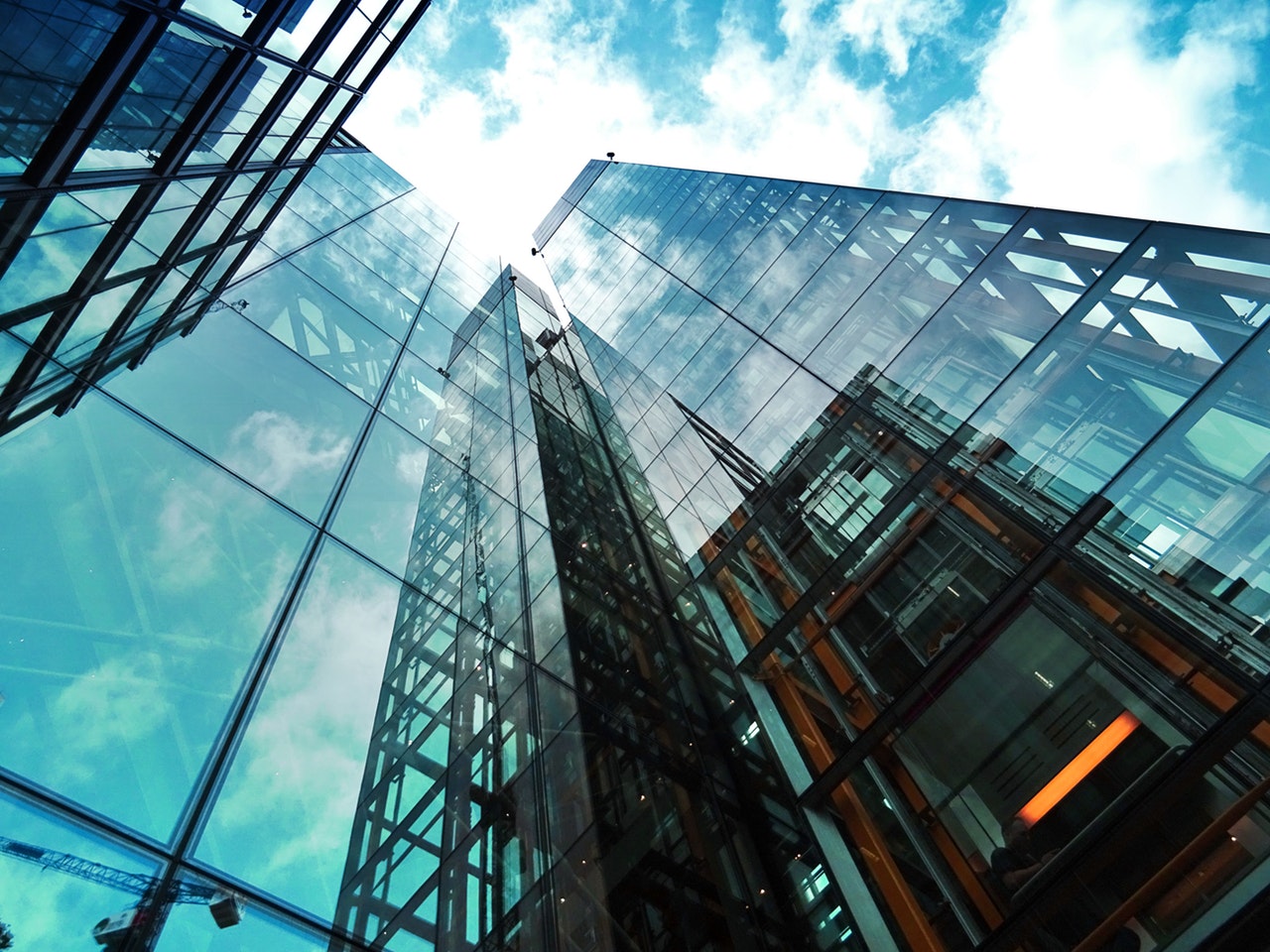 A photo of tall glass buildings taken from the ground up