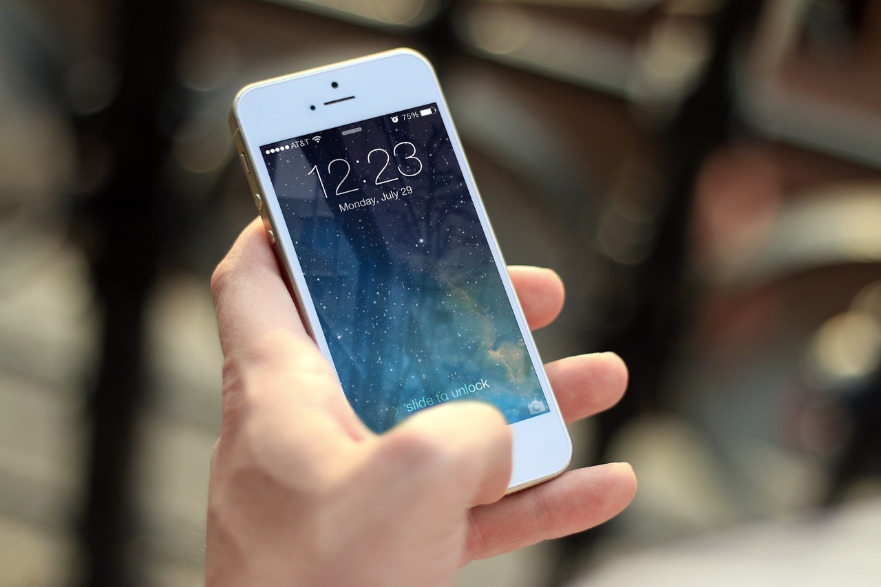 A person holding an iPhone. The screen is locked A person holding an iPhone. The screen is locked
