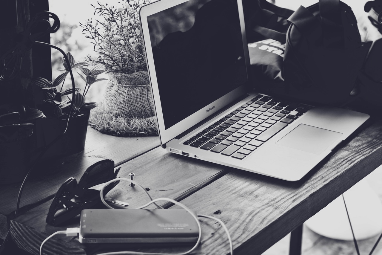 A black and white image of a workbench with a laptop, USB port and various other items placed on it